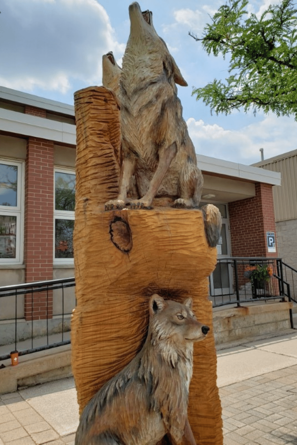 Tree sculpture with coyotes carved into the trunk